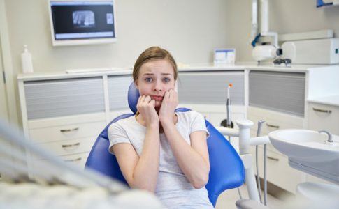 Junge Frau hat Angst beim Zahnarzt