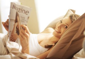 Frau im Bett mit Magazin