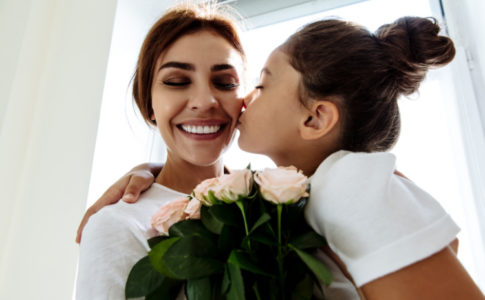 Mädchen schenkt Mutter Rosen