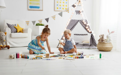 2 Kinder sitzen im Kinderzimmer und spielen miteinander